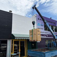 Crane lifting an air conditioning unit onto the roof of Angelwood Pies in Leederville.