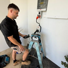Electrician installing a Fronius EV charger in a home garage, Perth.
