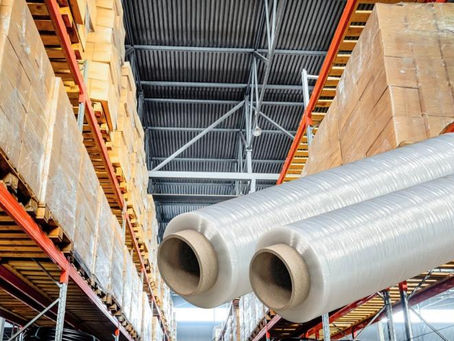 Rolls of pre-stretched film wait to be used in a warehouse