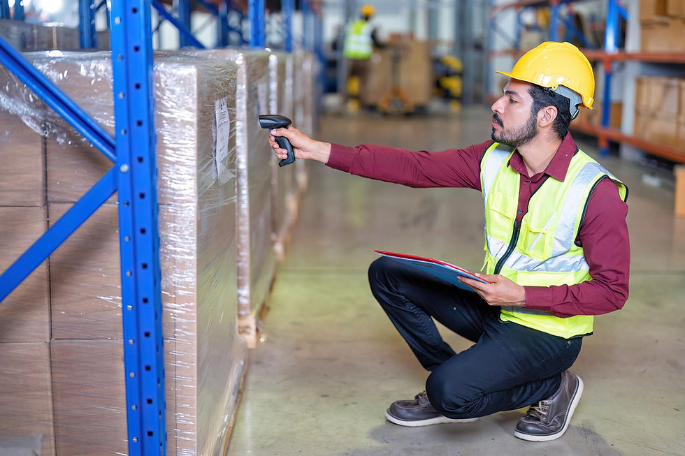 A worker scans a stretch-wrapped pallet