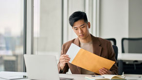 ผู้ชายกำลังจัดเก็บเอกสารสำคัญก่อนจัดส่ง และมองหาบริการส่งเอกสารสำคัญทางธุรกิจ