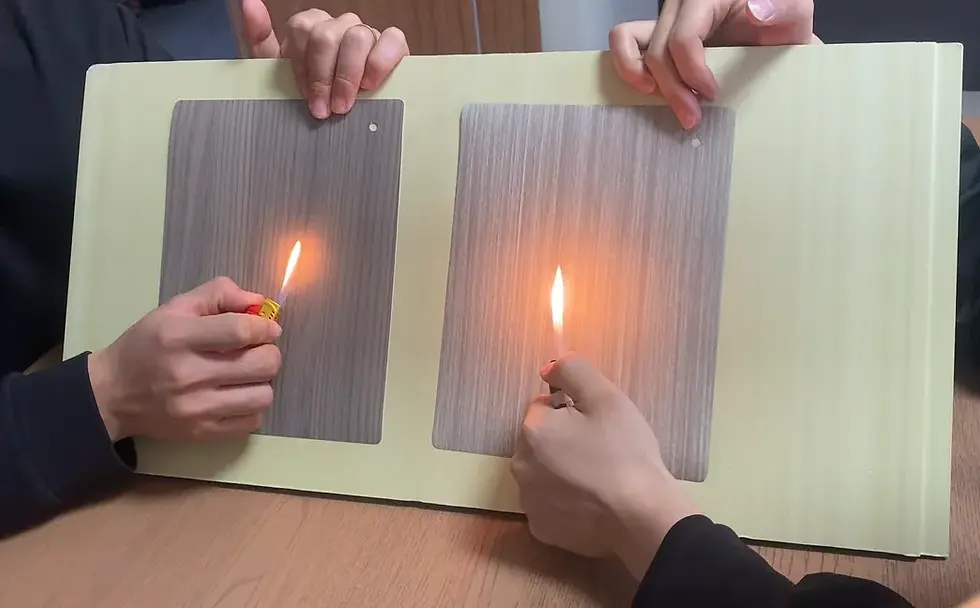 Dark woodgrain decorative film held above an open flame during a fire-retardant test, controlled lab setting, realistic texture, professional product demonstration