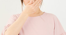 口を押える女性
