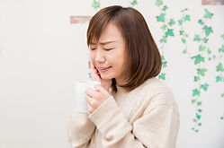 頬を押えて痛がる女性
