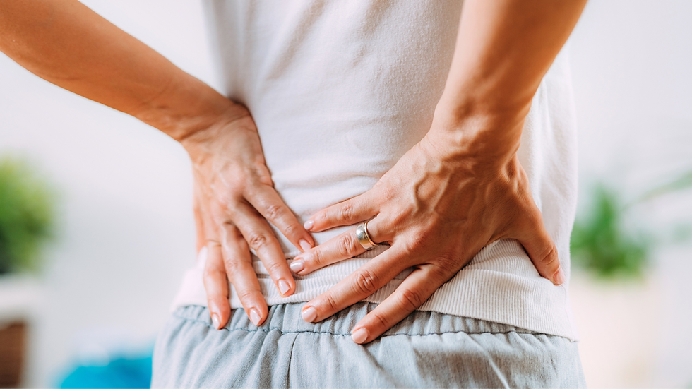 Person holding their lower back due to lower back pain or discomfort.