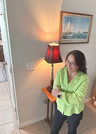 a picture of the CEO of the company Maria Phipard, standing wearing black pants and a bright green shirt, crossing her arms by her chest
