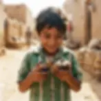 Candid photography of a young boy holding a toy with a joyful expression on a dusty village street. The image evokes innocence and simple happiness.