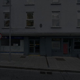 Exterior view of a building with visible signage. Greg Nolan Solicitors.