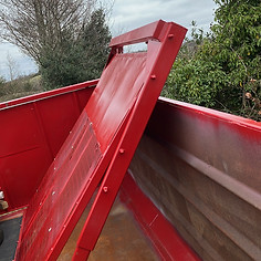Red trailer with wooden floor and raised metal ramp