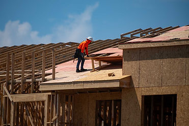 Worker installing roof on new house construction