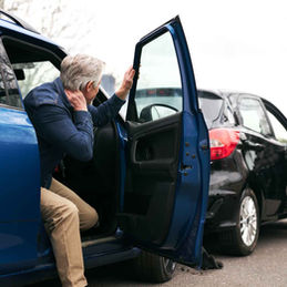 Two men assess car accident damage; Personal Injury, both on the phone