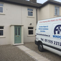 White house with a green door and A & R Windows van parked.