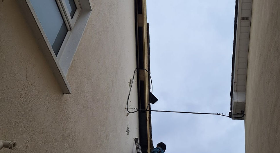 Exterior of a building with visible roof, FASCIA, SOFFITS & GUTTERS, and windows.