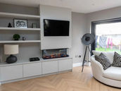 Modern living room with built-in shelving, fireplace, and comfy seating