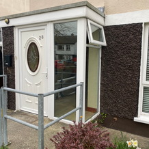White door with 2/A and glass replacement offers a welcoming entrance in front.