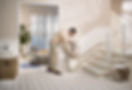 Man folding down stairlift seat on curved indoor staircase.