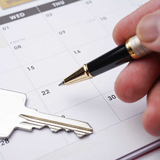 Hand pointing to a calendar date, key lies beside it