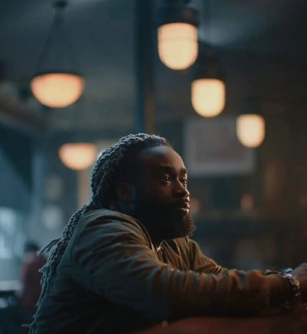 Man with dreadlocks at bar, looking thoughtfully, Eoghan Hand Lighting.