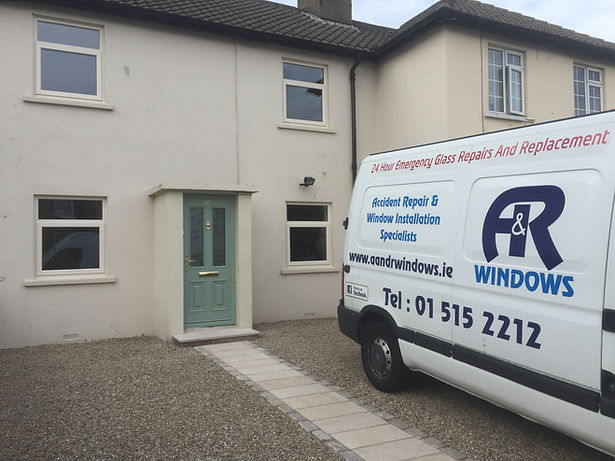 White van with A & R Windows parked in front of a house.
