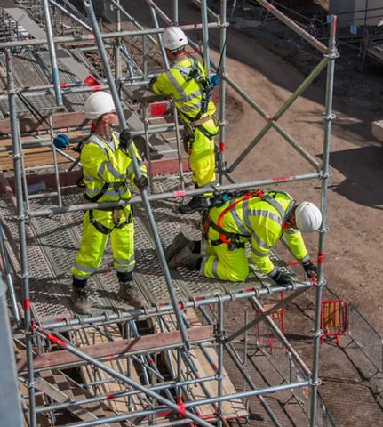 Workers assembling scaffolding on construction site