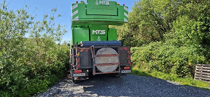 Green MTS crane on truck, parked outdoors