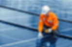 Technician inspecting solar panel array