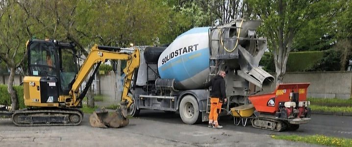 SolidStart concrete mixer and excavator at a job site
