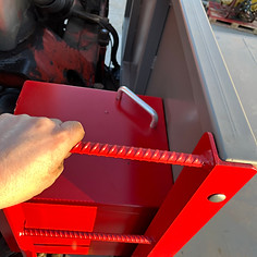 Hand gripping red rebar on equipment