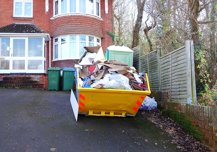 Full rubbish skip outside house