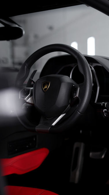 Black leather car steering wheel with red accents
