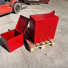 Red metal boxes, one open, one closed on pallet