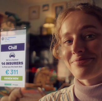 Woman holding phone screen showing Chill insurance quote for €311 with Renew Now.