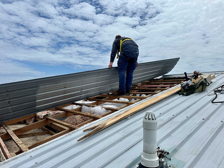 Worker installing new roof metal sheeting