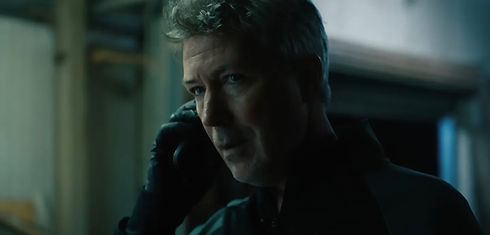 A man with grey hair on the phone in a dimly lit room. Eoghan Hand Lighting