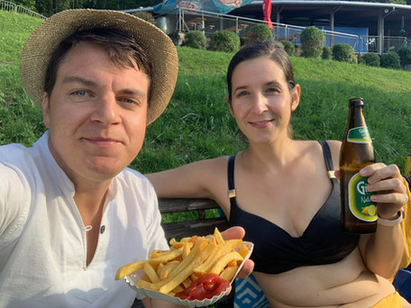 Mann und Frau essen Pommes und trinken Radler