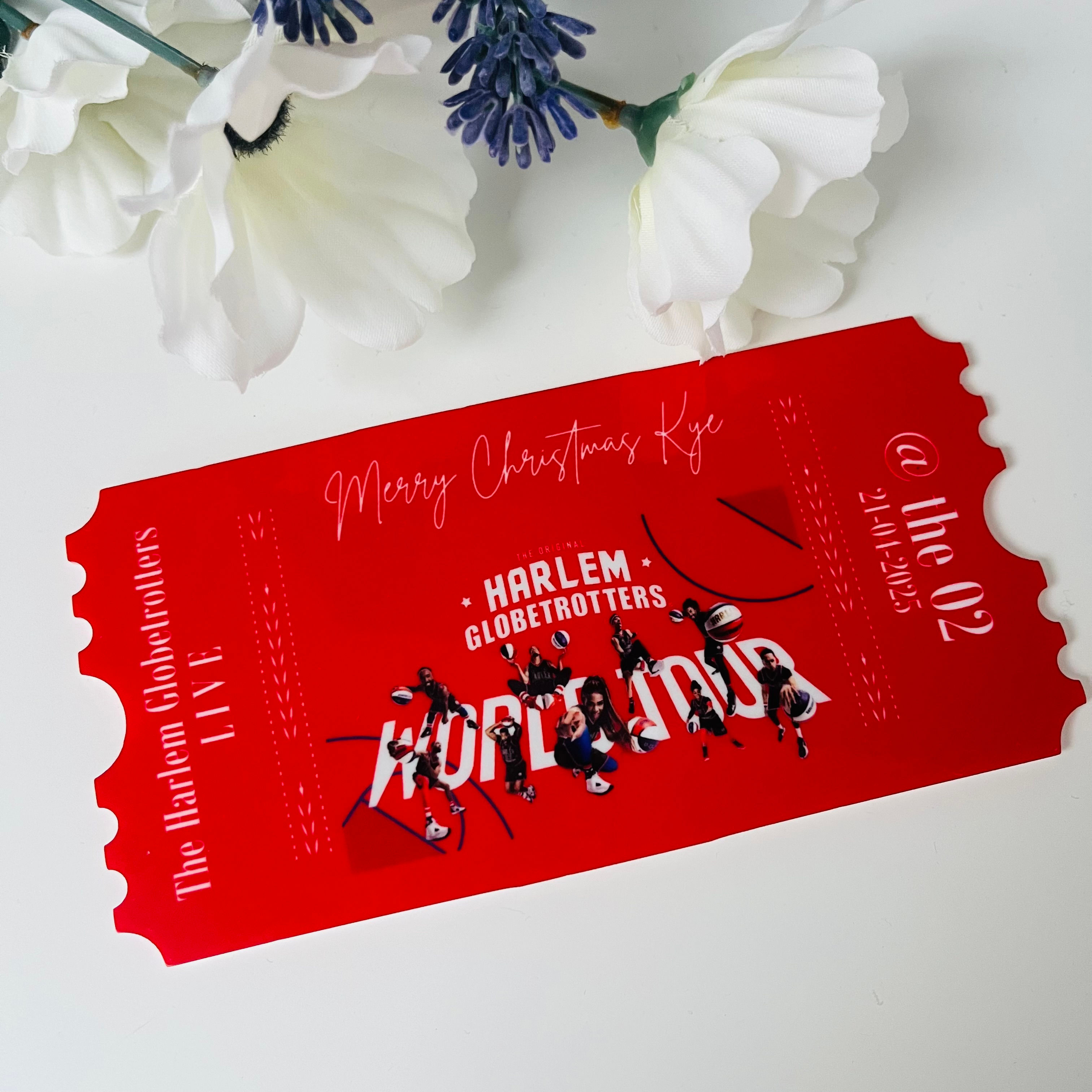 A red acrylic ticket with an image of the harlem globtrotters on it and details of the event