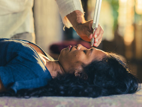 Pose d’un diapason thérapeutique sur le point Yin Tang, entre les sourcils, pour harmoniser le champ énergétique et favoriser un état de calme profond.