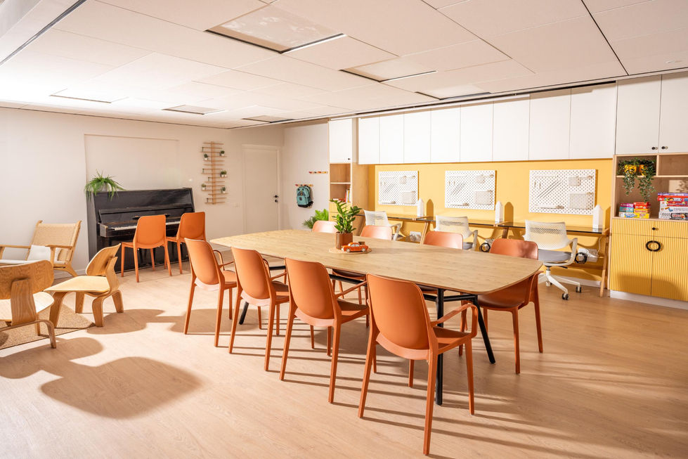 שני שולחנות עץ גדולים עם כיסאות כתומים