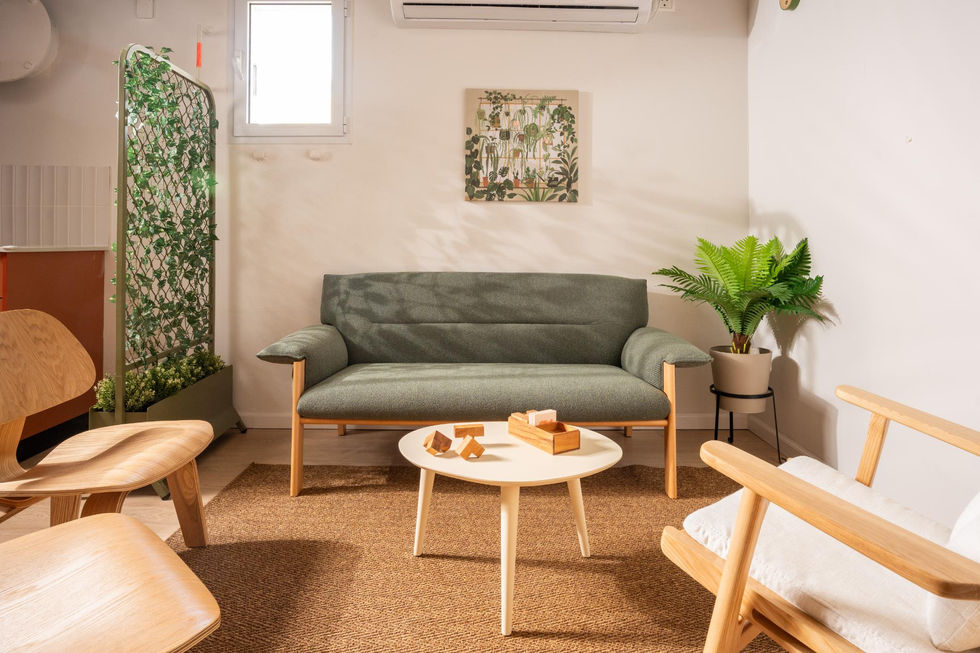 ספה אפורה-ירוק וכורסאות עץ בפינת אירוח