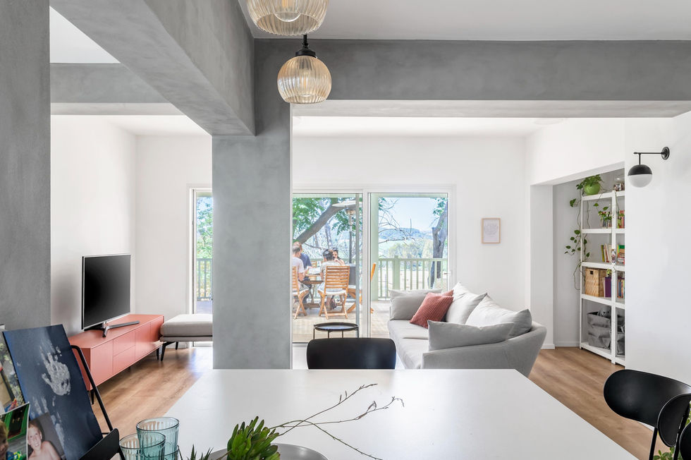 ספת ישיבה קטנה ליד חלון מואר עם צמח ירוק