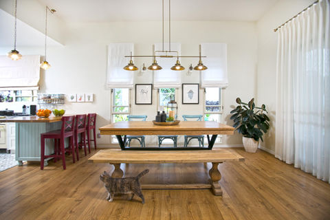 פינת אוכל כפרית עם שולחן עץ, קיר תמונות וגופי תאורה תעשייתיים