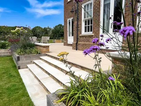 eautiful large traditional garden design in East Sussex with spacious stone garden steps, oak raised beds, and vibrant purple verbena, part of a full landscaping and garden build project