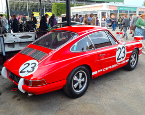 En klassisk röd Porsche 911 från 60-talet med de klassiska Fuchs-fälgarna, racingbur och racedekor.