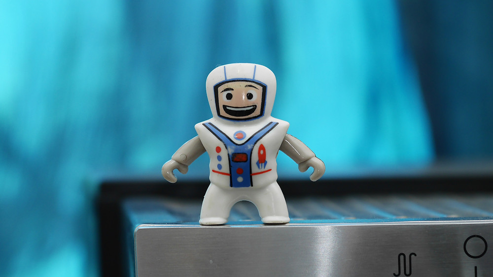 White toy astronaut on blue background