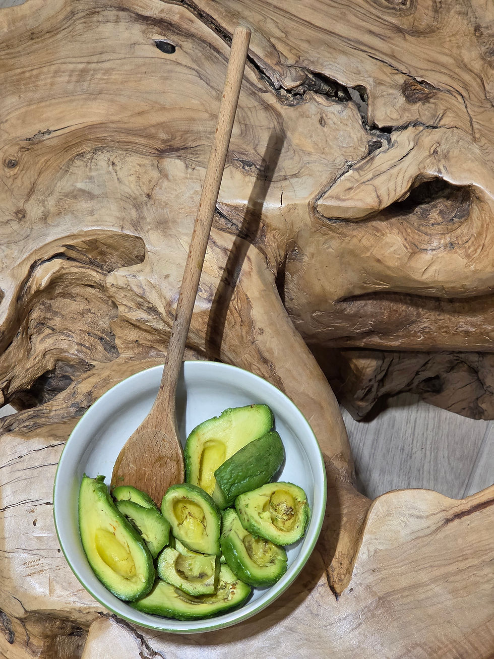 Avocado tagliati in una ciotola con cucchiaio di legno