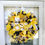 Thumbnail: A charming yellow and black bumblebee wreath adorned with bees and gnomes.