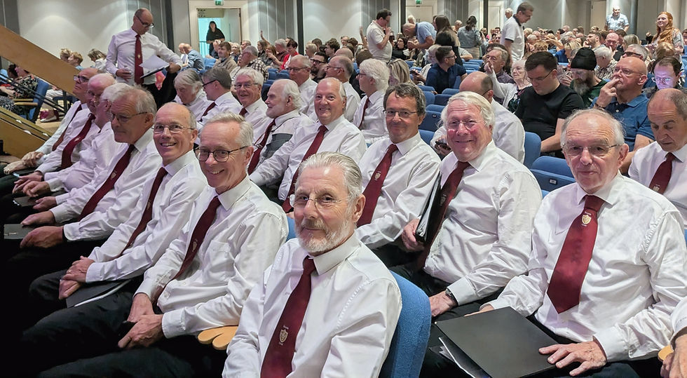 KMVC choir members sitting at the front of Birmingham Town Hall before performing