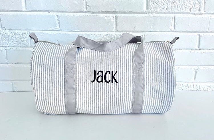 Thumbnail: White duffel bag with the name "JACK" on it against a wall.