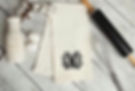 White towel with a black ornate MC monogram, next to baking tools.