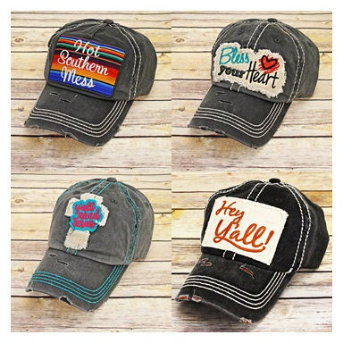 Miniatura: Four gray hats with colorful patches and text on a wooden surface.